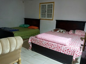 Un dormitorio con dos camas individuales, un sofá y una ventana.