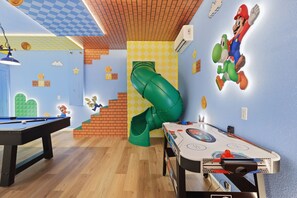 A room with a pool table, a green slide, and Mario and Luigi wall decals. - Disney 6BR/4BA Themed Rooms & Pool LED TV BV4509 (Kissimmee)
