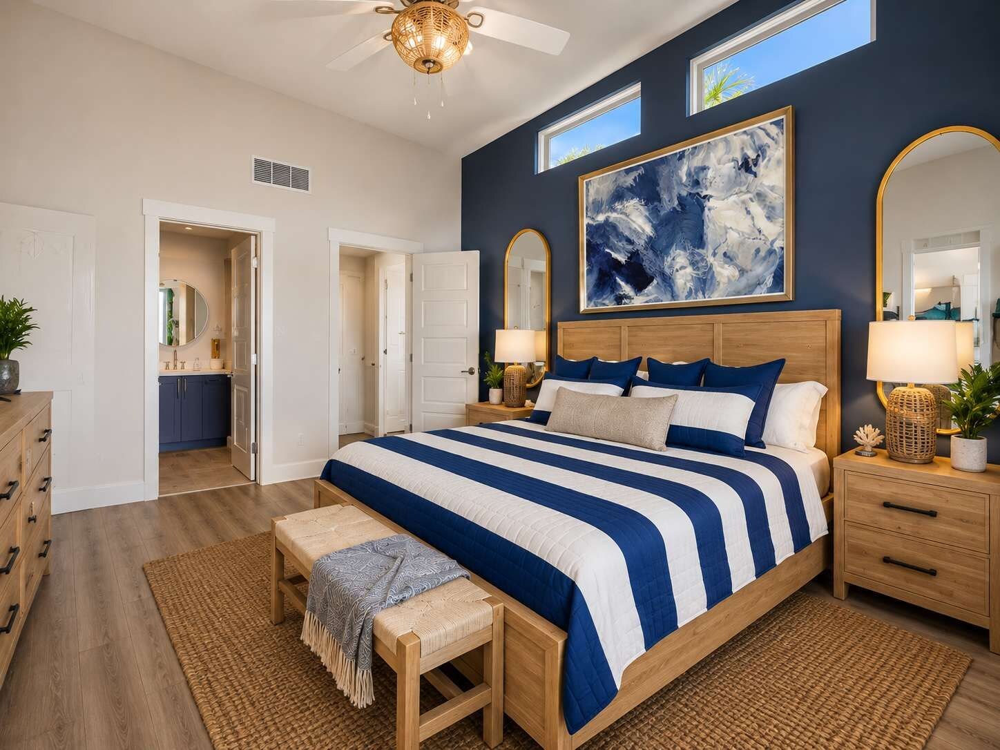 A bedroom with a large bed, bedside tables, a ceiling fan, and a large abstract painting on the wall.