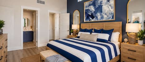A bedroom with a large bed, bedside tables, a ceiling fan, and a large abstract painting on the wall.