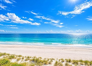 A beach with clear blue water and a sandy shore. - 2 Homes, Steps to Beach, 2 Hot Tubs, 4 Kings. (Indian Rocks Beach)