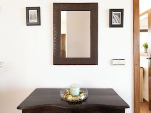 A dark wooden table with a glass candle holder and a framed picture above it. - Portichuelo by Interhome (Almuñécar)