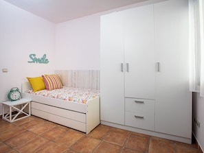 A bedroom with a bed, a wardrobe, a bedside table, and a wall-mounted clock. - Portichuelo by Interhome (Almuñécar)