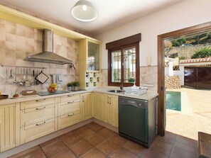 A kitchen with a dishwasher, a window with a view, and a tiled backsplash. - Portichuelo by Interhome (Almuñécar)