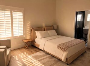A bedroom with a bed, bedside table, lamp, and a view of a bathroom. - Luxury Newly Renovated Modern Retreat - Vineyard & Golf Course Views (Escondido)