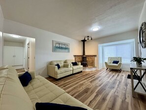 A living room with a fireplace, a sofa, a chair, and a table.