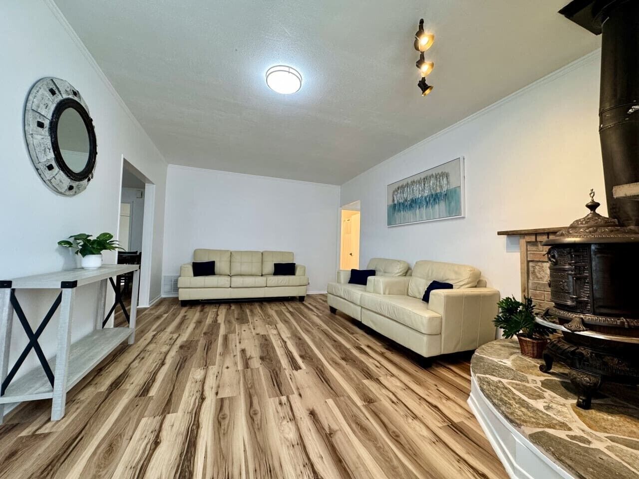 A living room with a fireplace, two sofas, a coffee table, and a wooden floor.