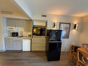 A compact kitchen with a black refrigerator, a microwave, and a coffee maker. There are cabinets and a sink. - OASIS FAMILY COTTAGE STUDIO-1BEDROOM (Oro-Medonte)