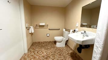 A small bathroom with a toilet, sink, and a mirror.