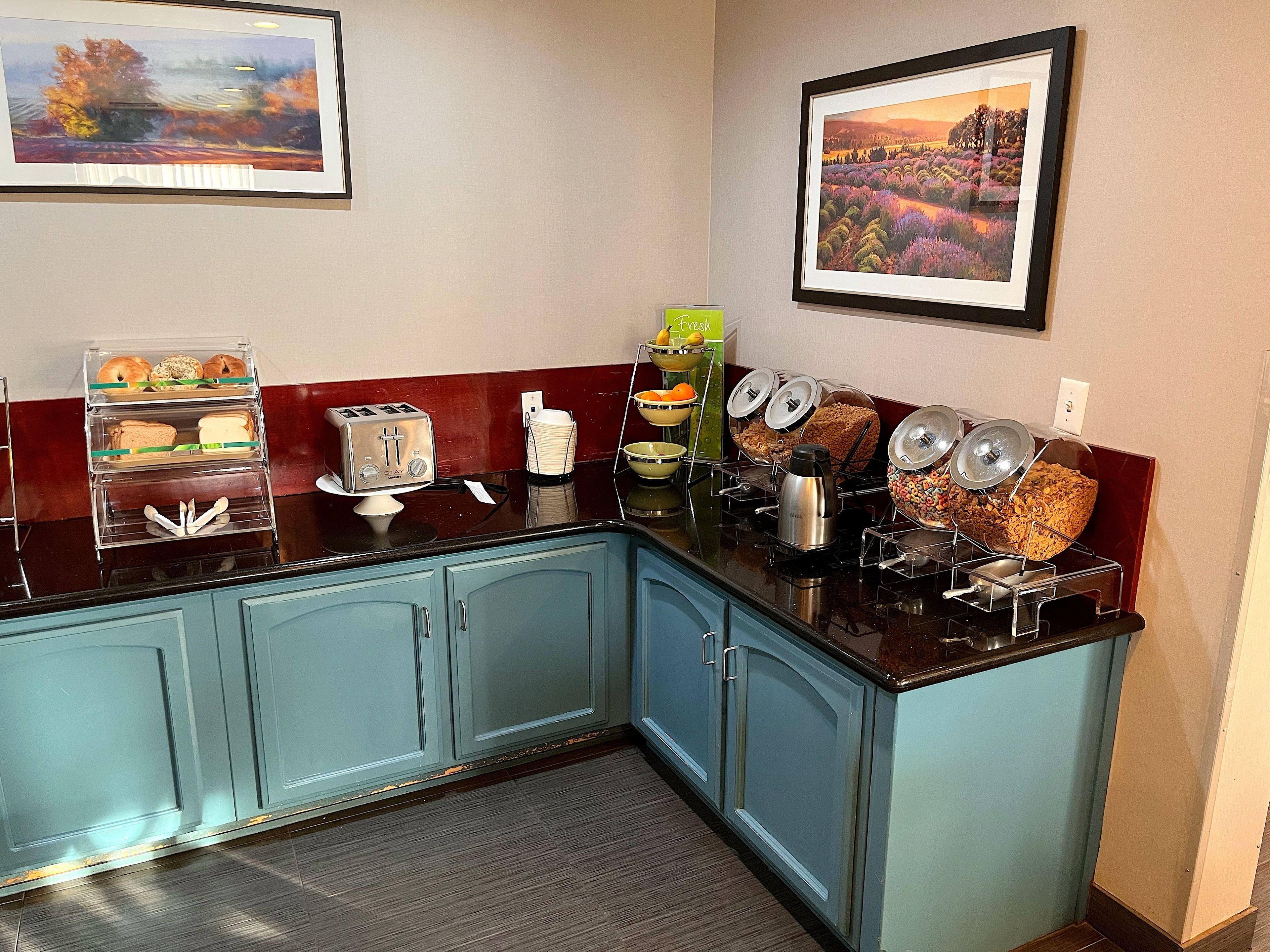A kitchenette with a toaster, a coffee maker, and various food containers.