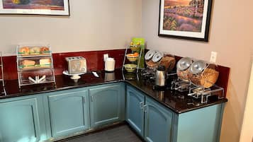 A kitchenette with a toaster, a coffee maker, and various food containers.