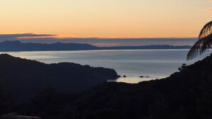 Paisaje costero con vista al mar y montañas distantes.