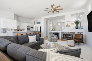 Ein modernes Wohnzimmer mit einem grauen Ecksofa, einem Couchtisch und einem Kamin.