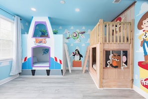 A children's playroom with a bunk bed, a playhouse, and wall decorations including Buzz Lightyear and Woody from Toy Story. - Encore 10BR Escape with Pool, Spa & Game Room (Kissimmee)