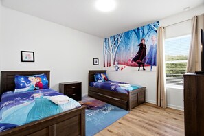 Ein Schlafzimmer mit zwei Betten, einem Nachttisch, einer Kommode, einem großen Fenster mit Vorhängen und einer Wandmalerei.