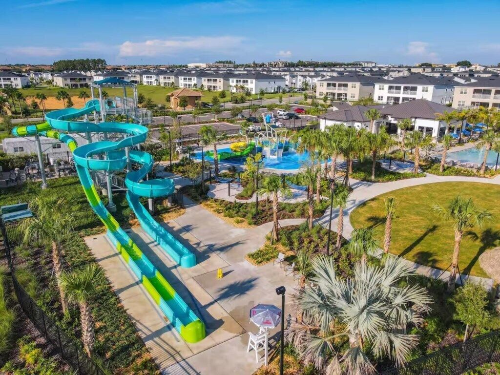 Un parc aquatique doté de nombreux toboggans et de plusieurs piscines, entouré d’immeubles d’habitation.
