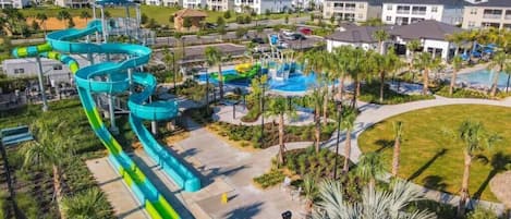 Un parc aquatique doté de nombreux toboggans et de plusieurs piscines, entouré d’immeubles d’habitation.