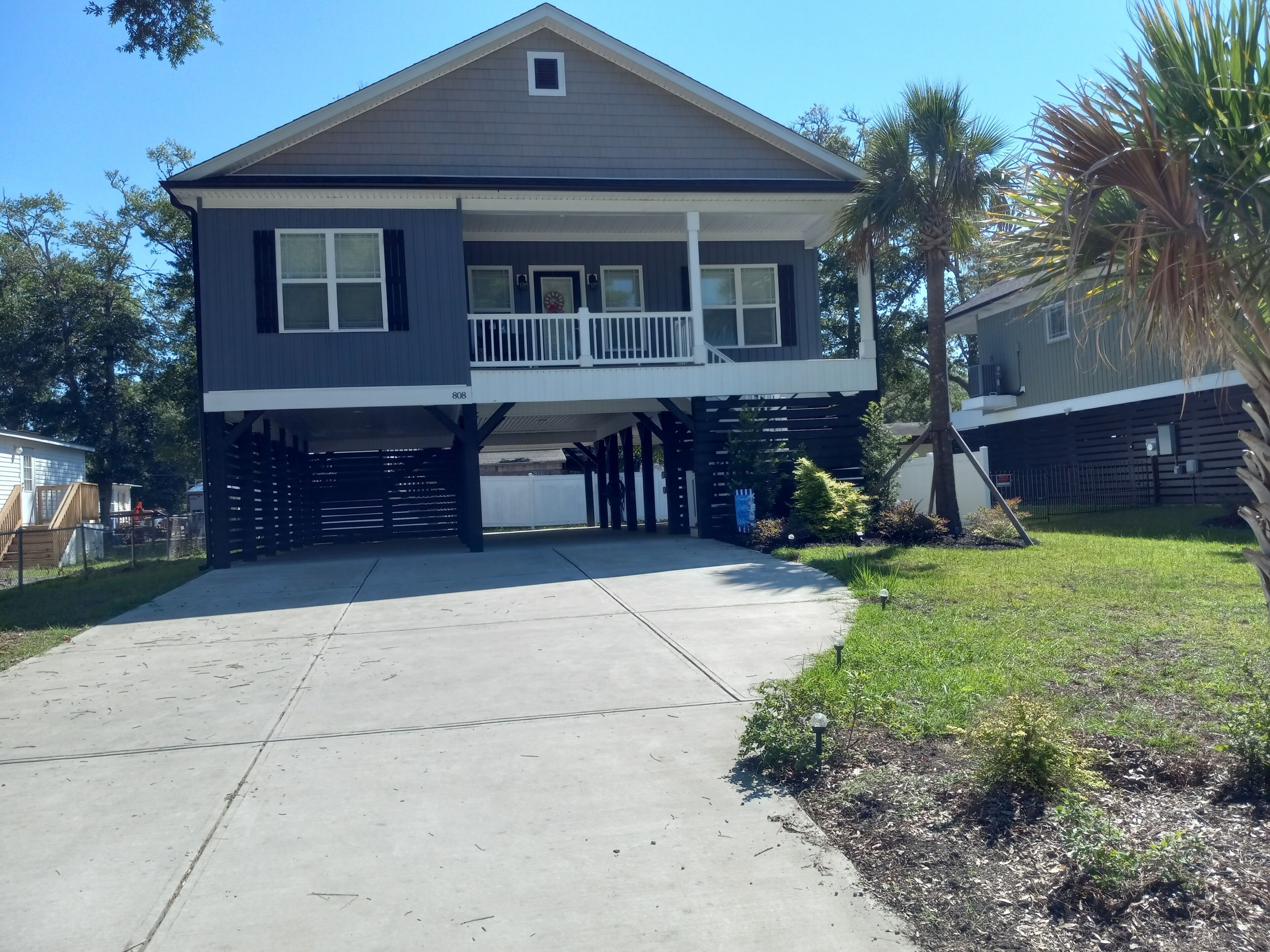 A two-story house with a covered garage, a balcony, and a well-maintained lawn.