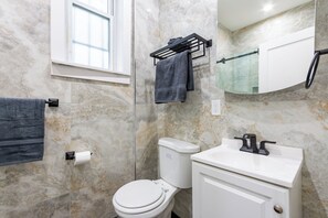 A bathroom with a toilet, sink, towel rack, and a mirror. - Stylish Brooklyn Apartment Natural Light (Brooklyn)