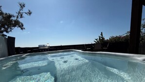 A hot tub with a clear view of the sky and a barbecue grill in the background. - Pacific Beach Retreat Bay Views + Hot Tub (San Diego)