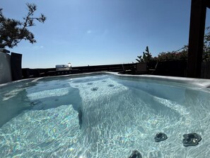 A hot tub with a clear view of the sky and a barbecue grill in the background. - Pacific Beach Retreat Bay Views + Hot Tub (San Diego)