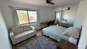 A bedroom with a bed, a sofa, a desk, and a ceiling fan. - Pacific Beach Retreat Bay Views + Hot Tub (San Diego)