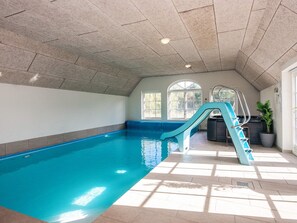 An indoor swimming pool with a blue slide, a staircase, and a potted plant. - 4 Star Holiday Home in Ulfborg (Ulfborg)
