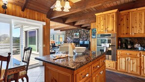 A kitchen with wooden cabinets, granite countertops, and a stone backsplash.