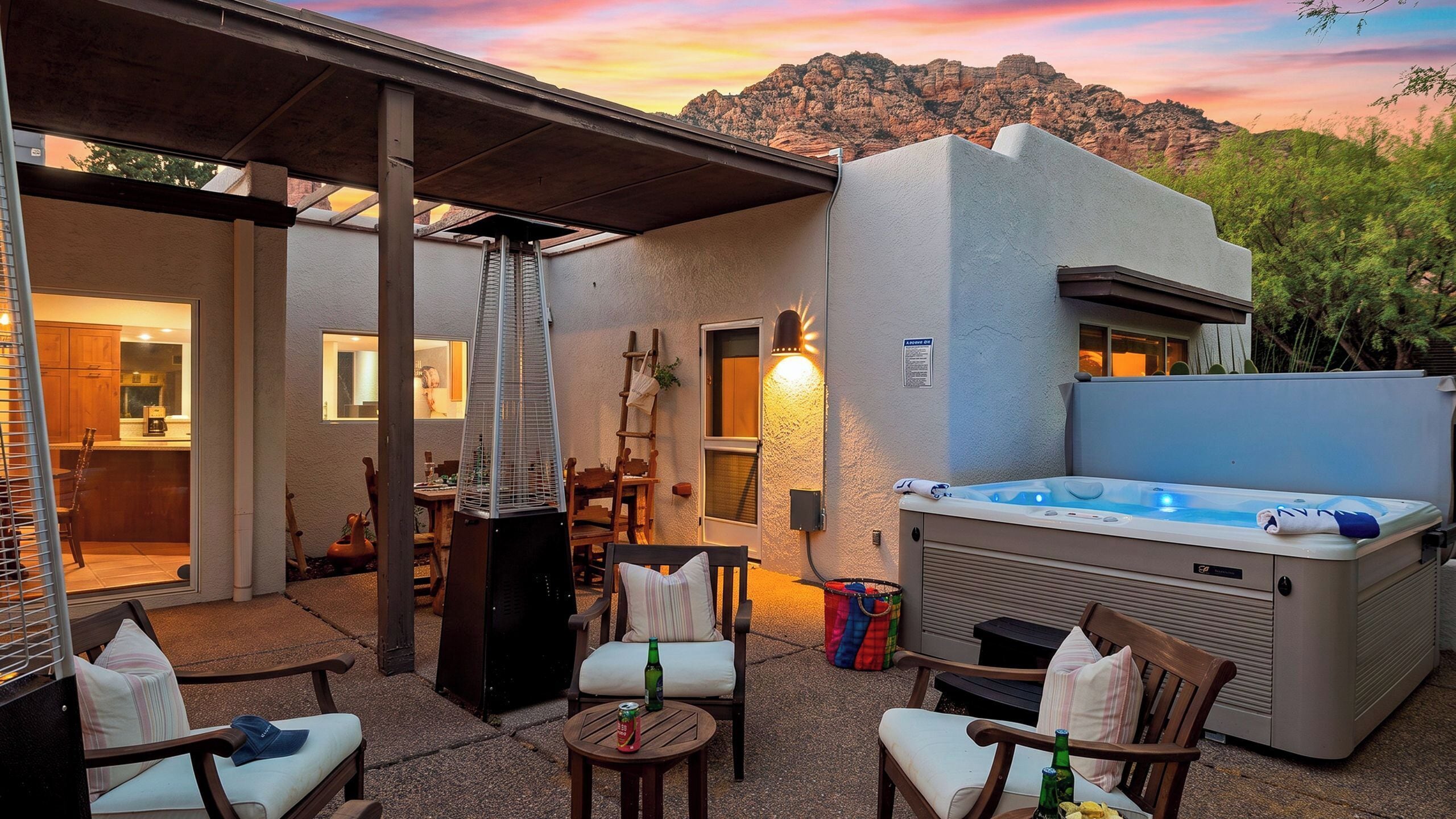 A patio area with outdoor seating, a hot tub, and a view of a mountain range.