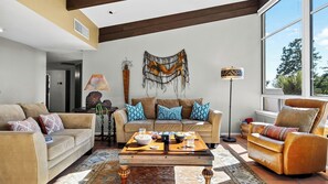 Uma sala de estar com sofá, mesa de centro e um enfeite de parede.