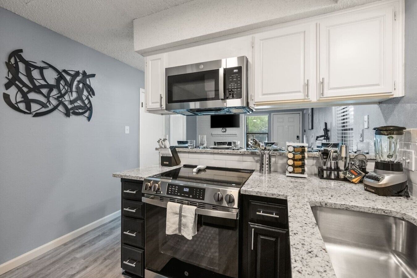 A modern kitchen with a stainless steel range, a microwave, and a built-in oven.
