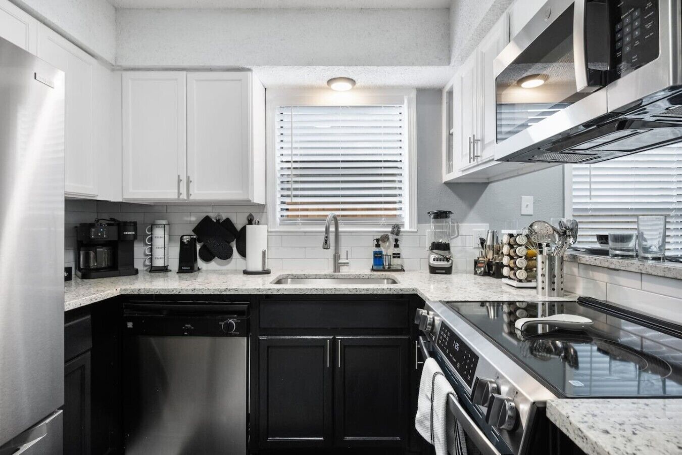 A modern kitchen with a dishwasher, stove, and coffee maker.