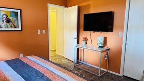 A bedroom with a bed, a bedside table, a TV, and a door. - Stylish Lakefront Retreat, Pet Friendly, Flexible King/Twin Setup, Mins to Beach (Venice)