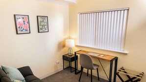 Ett kompakt bostadsutrymme med ett skrivbord, en stol och en soffa.