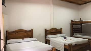 A room with three wooden beds, a bunk bed, and a ceiling fan.