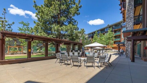 An outdoor patio area with a pool table, lounge chairs, and a pergola. - Ski-In King Executive Resort Suite w/ Mtn Views, Pool & Garage! (Mammoth Lakes)