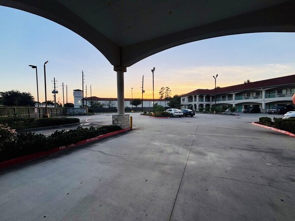 A parking lot with a building in the background, a clear sky, and a sunset. - Humble Inn & Suites (Humble)