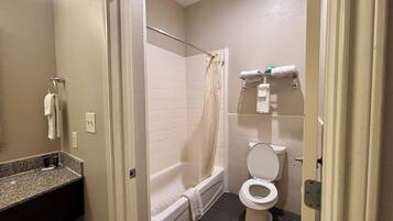 A bathroom with a bathtub, toilet, and a shower curtain.