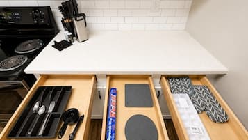 Een koffiezetapparaat/waterkoker, een koelkast, een oven, een kookplaat