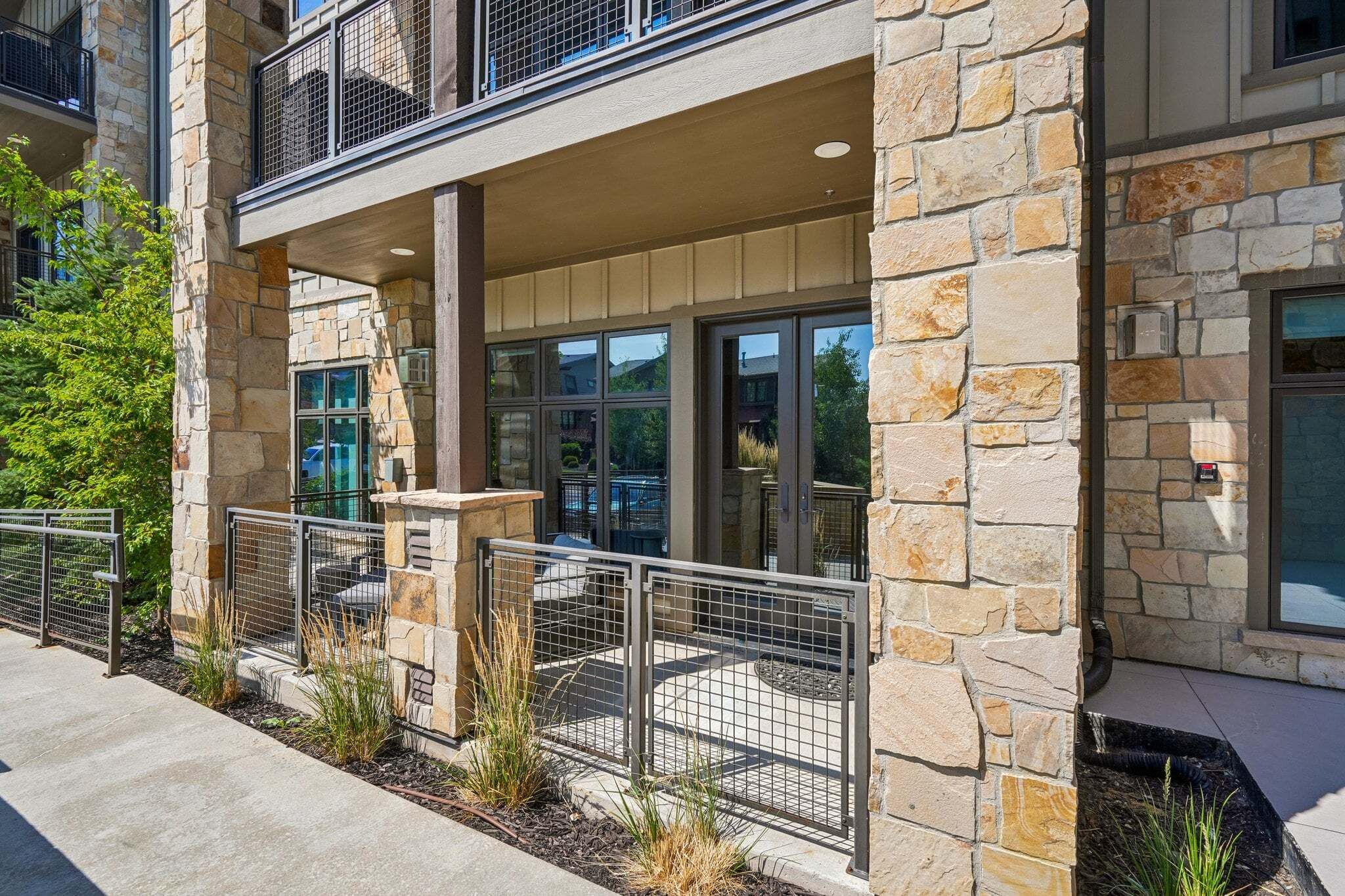 A multi-story building with stone facade, large windows, and a gated entrance.