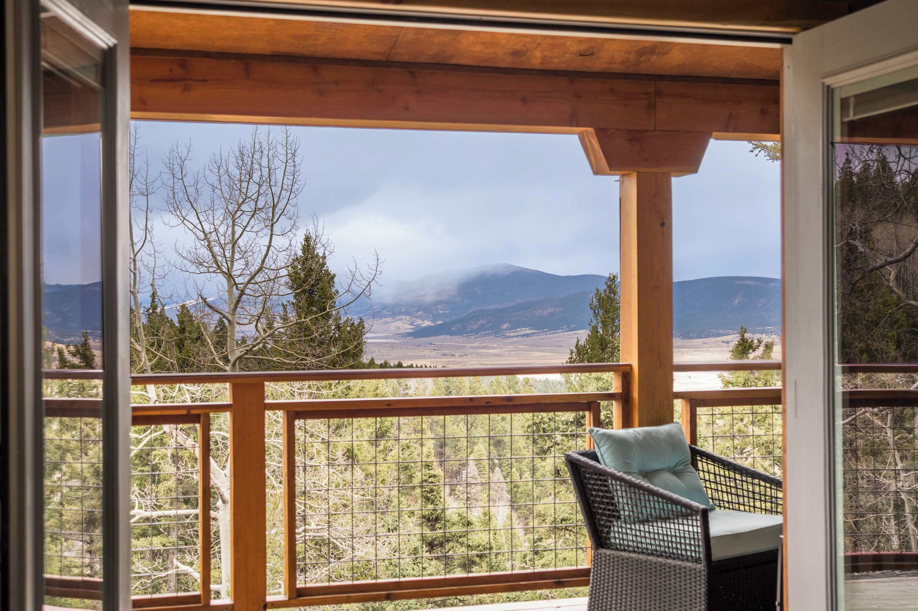 A balcony with a view of mountains and trees.