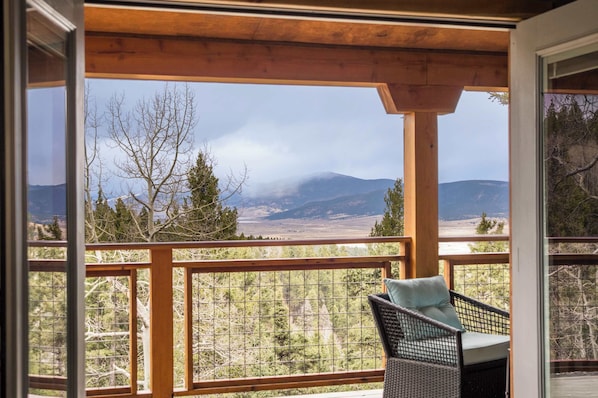 A balcony with a view of mountains and trees.