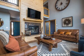 Ein Wohnzimmer mit Kamin, einer großen Uhr und einem Sofa.