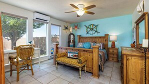 A room with a bed, a chair, a nightstand, a lamp, and a ceiling fan. - Casa de Colores - Adobe Retreat, Dog-Friendly, AC (Santa Fe)