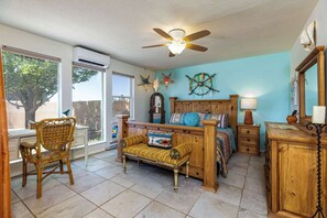 A room with a bed, a chair, a nightstand, a lamp, and a ceiling fan. - Casa de Colores - Adobe Retreat, Dog-Friendly, AC (Santa Fe)