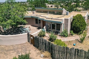 A modern house with a flat roof, large windows, and a fenced yard. - Casa de Colores - Adobe Retreat, Dog-Friendly, AC (Santa Fe)
