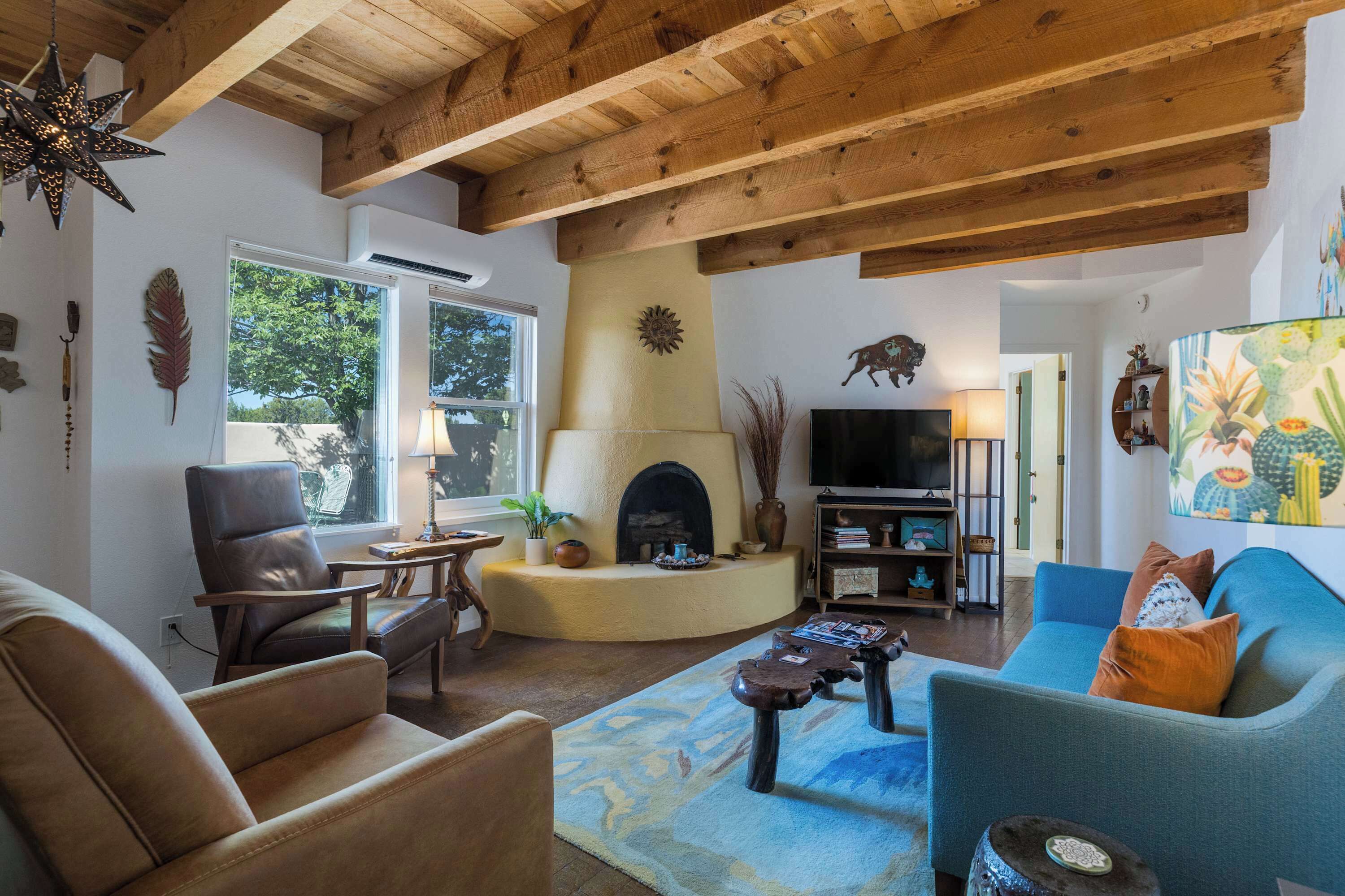 A cozy living room with a fireplace, seating area, and a television.