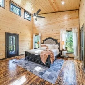 Ein Schlafzimmer mit einem Bett, einem Deckenventilator und einem Fenster.