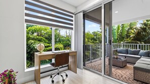 A modern room with a desk, chair, and a balcony with outdoor furniture. - Park & Palm by Avantstay Private Pool + 4 Ensuite Baths + BBQ Victoria Park + Las Olas (Fort Lauderdale)
