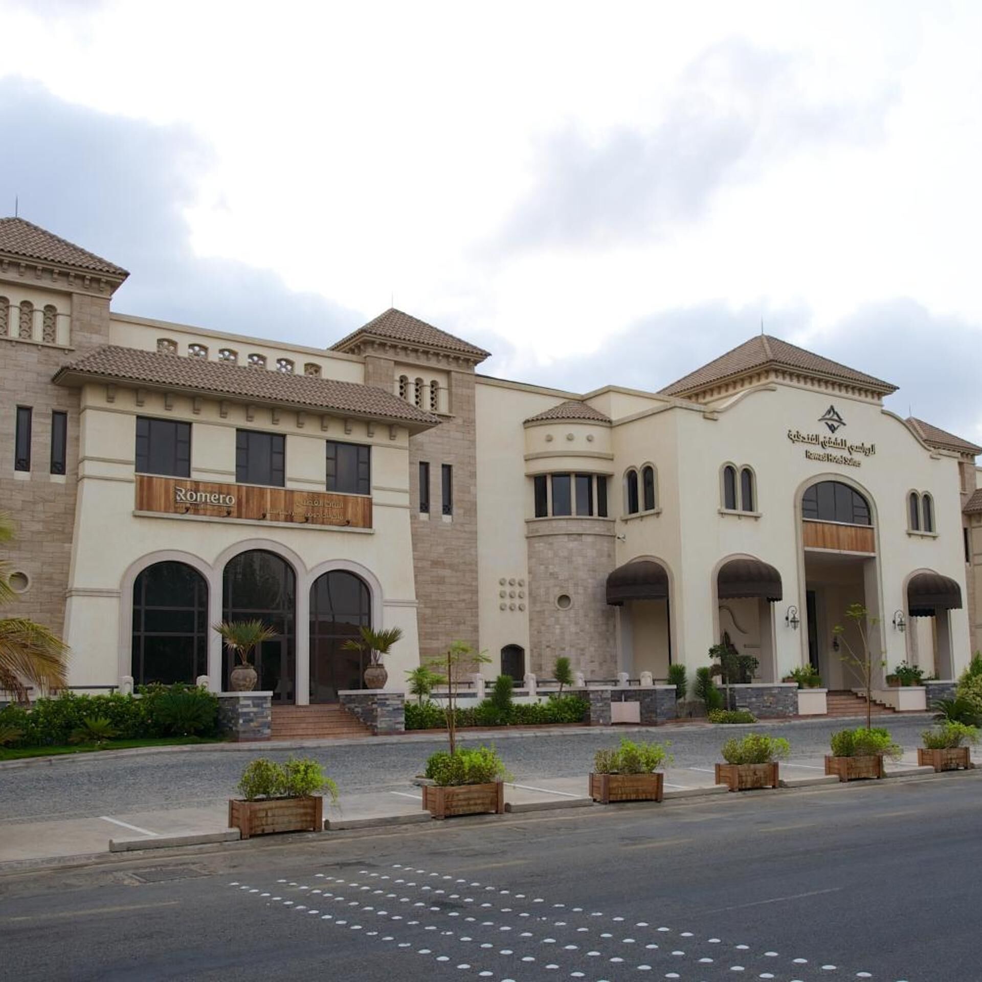 A hotel with a traditional architectural style, featuring arched windows and a central entrance.